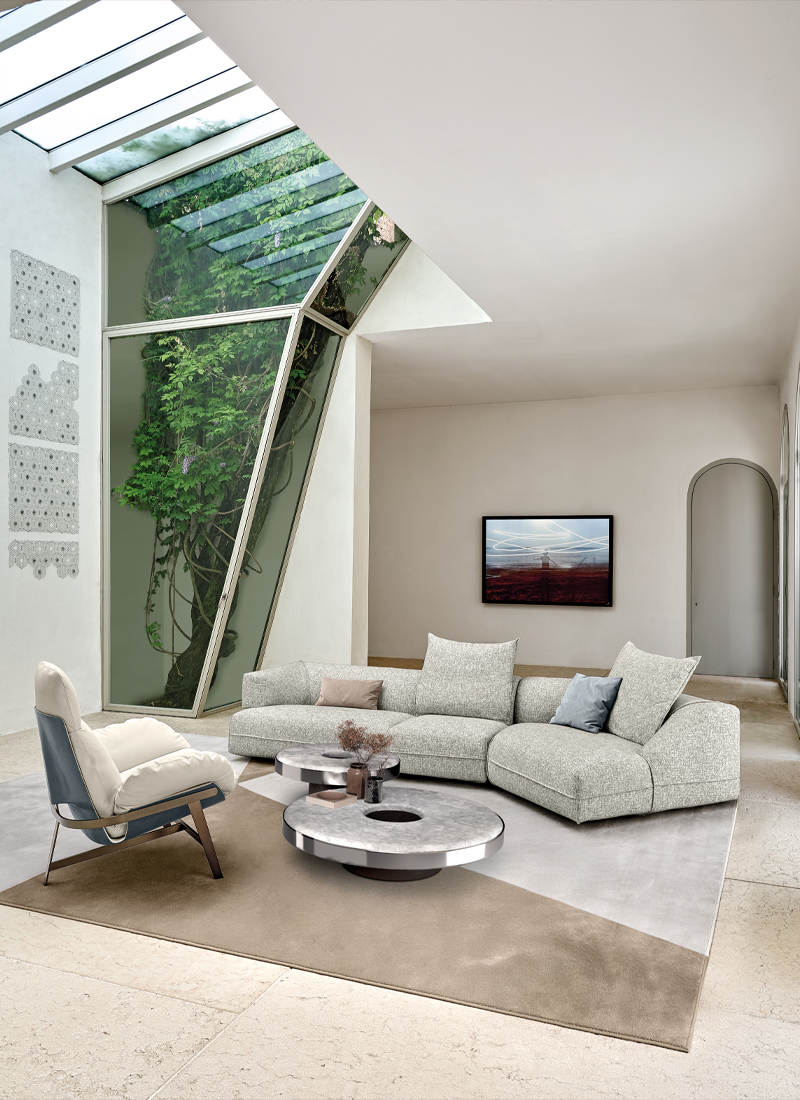 Arketipo Starman sofa and occasional tables in a light living room beneath a glazed roof.